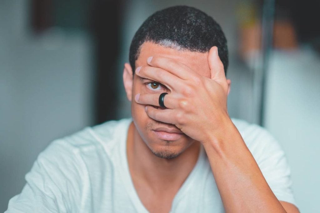 man covering face in denial