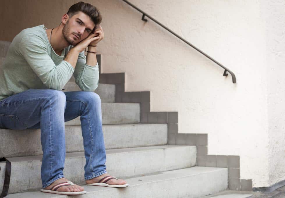 man sitting on steps looking sad