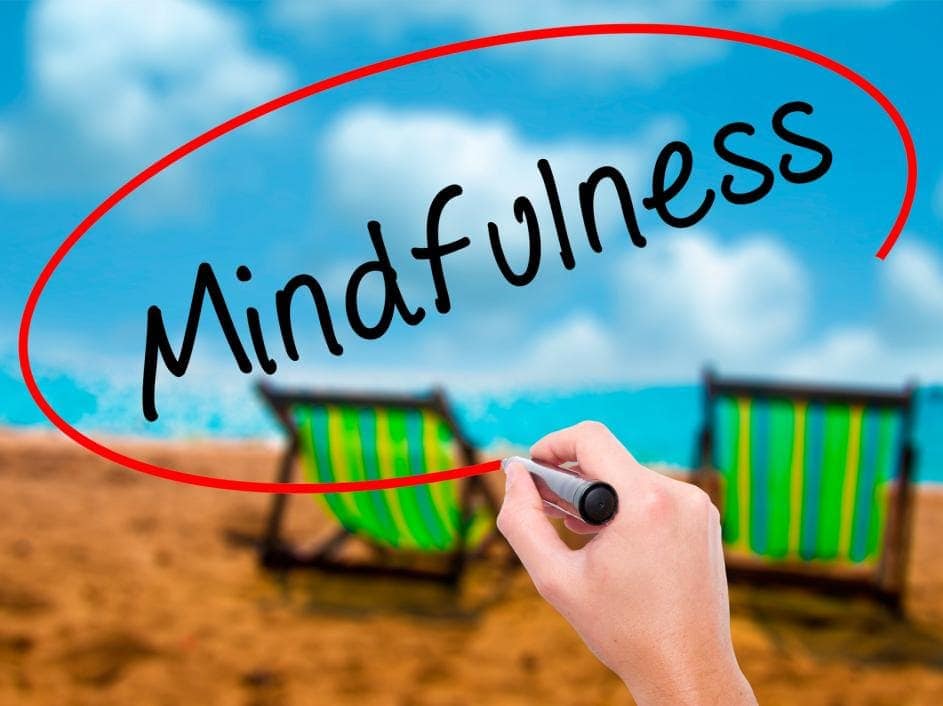 hand writing mindfulness on a screen