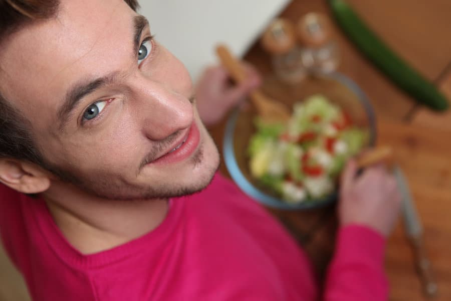 healthy habit: young man making a salad