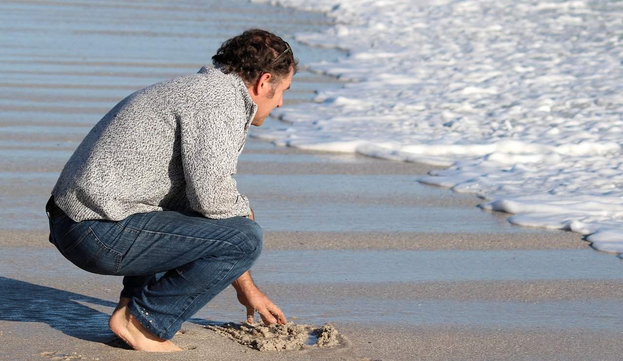 man barefoot on beach