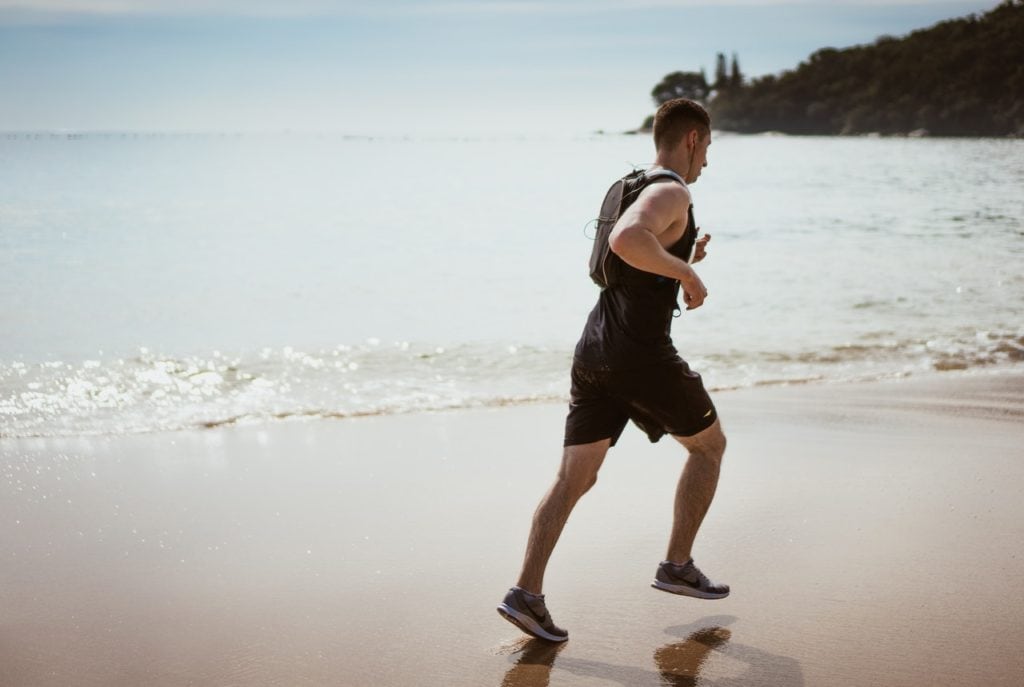 man in recovery doing exercise on beach jogging
